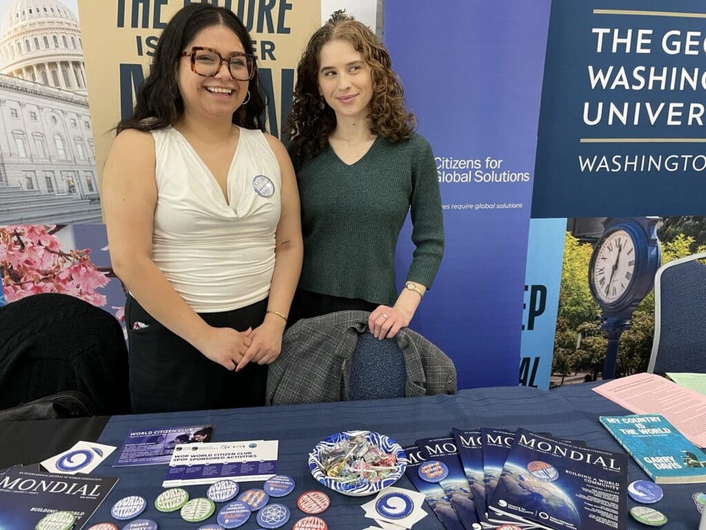 Two students staffing the Citizens for Global Solutions outreach table with Mondial newspapers and world citizen materials.