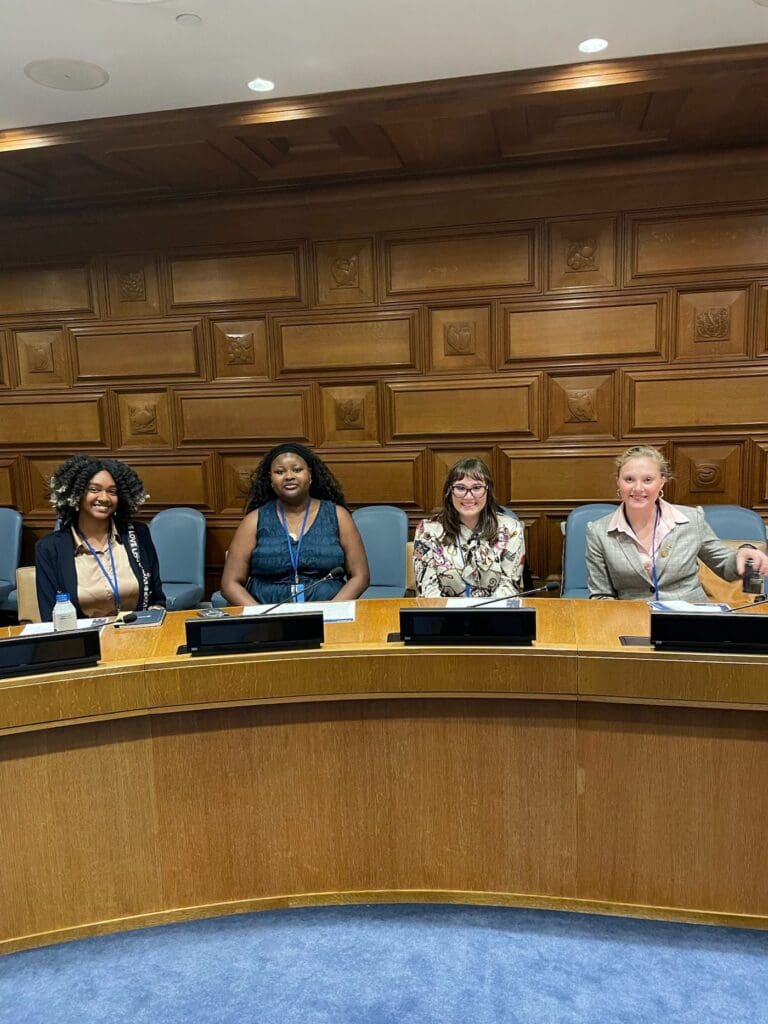 CGS delegates seated at the dais of a wood panelled United Nations chamber.