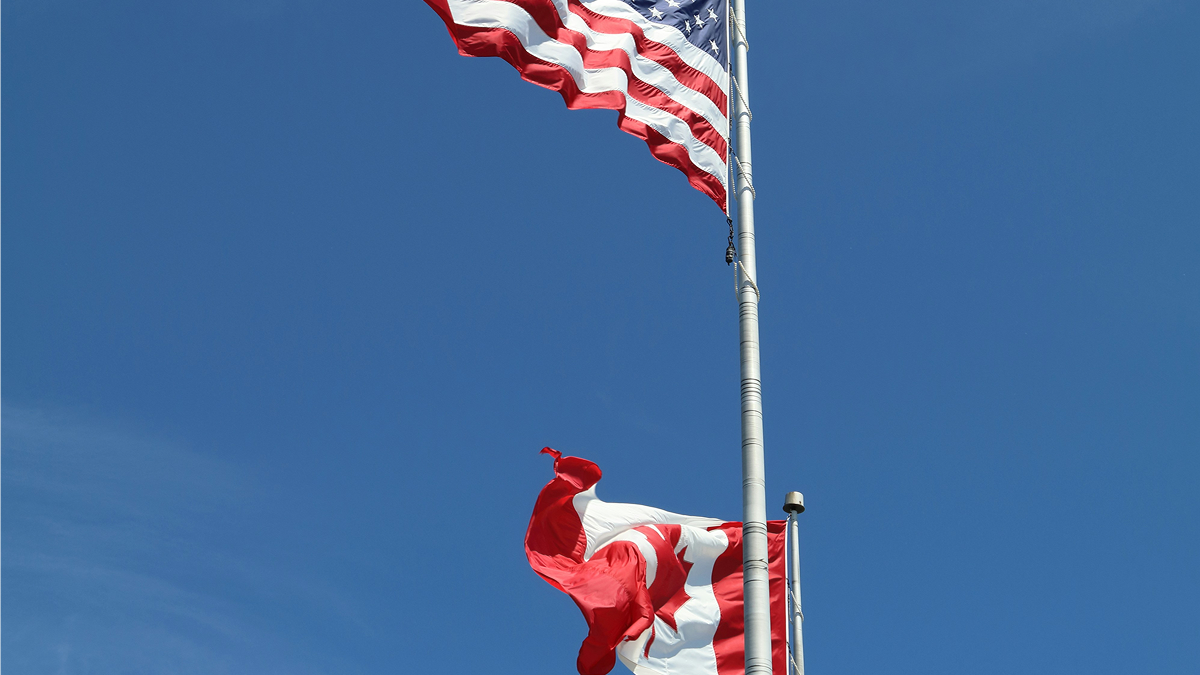 US and Canada flags on poles