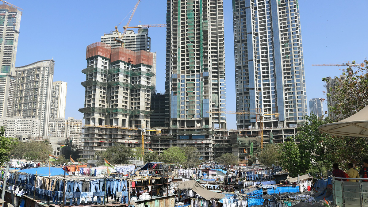 New high-rise towers under construction above a laundry settlement in Mumbai